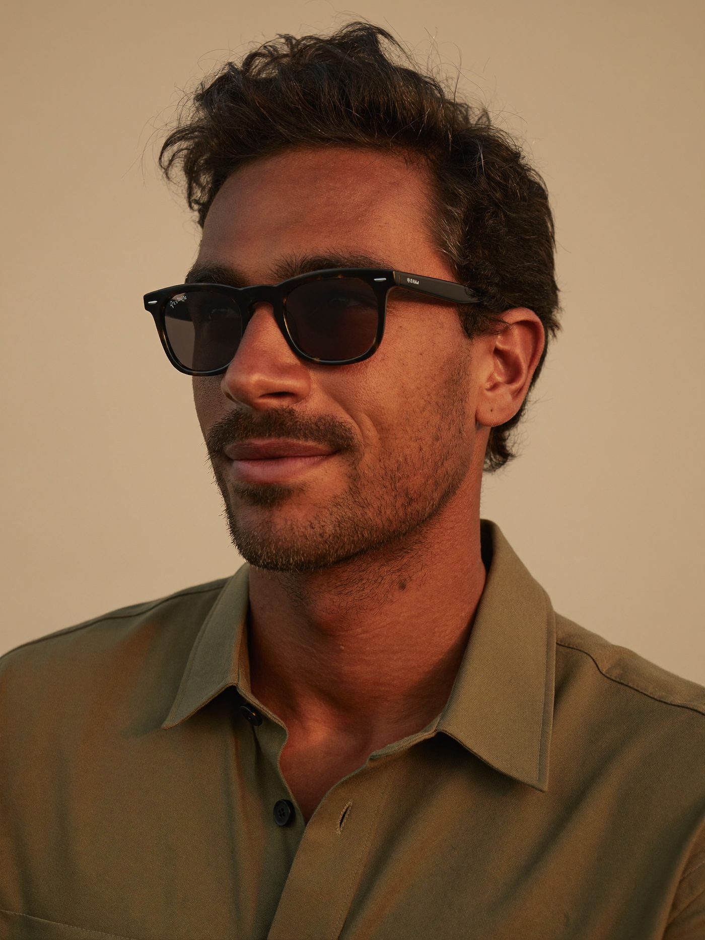 Homem sorrindo com óculos de sol clássico