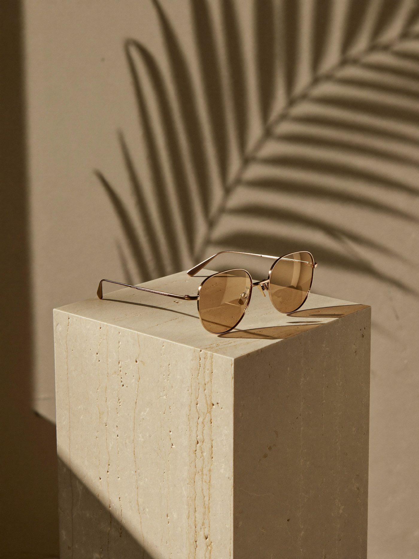 Armação rose gold sobre mármore com luz natural